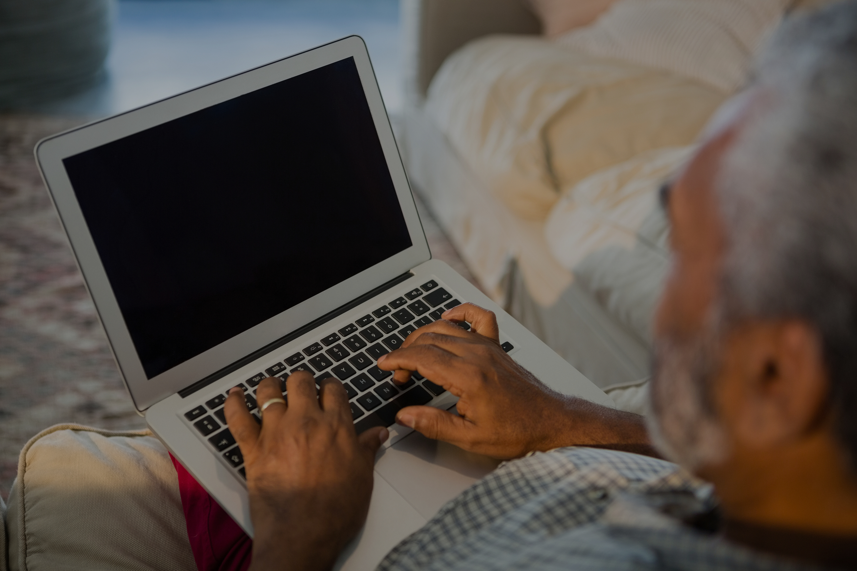 Senior man using laptop in the living room at home